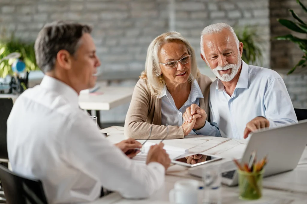 Senior couple reviewing insurance options with an agent at an Agencia de Seguros en Travis Heights, Austin, TX